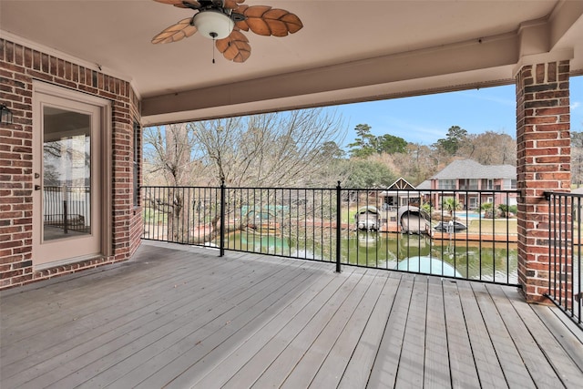 wooden terrace featuring a water view and ceiling fan