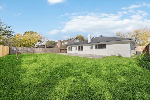 rear view of house featuring a yard and a patio area