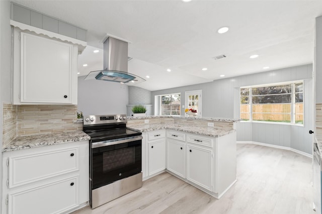 kitchen featuring stainless steel electric range oven, island range hood, white cabinets, and kitchen peninsula