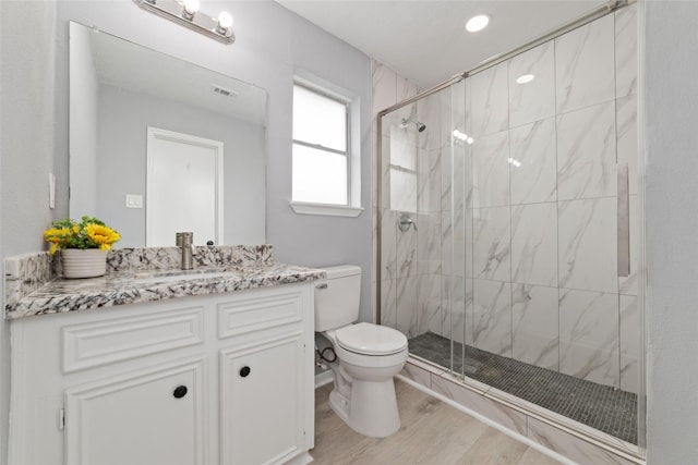 bathroom with vanity, toilet, a shower with door, and wood-type flooring