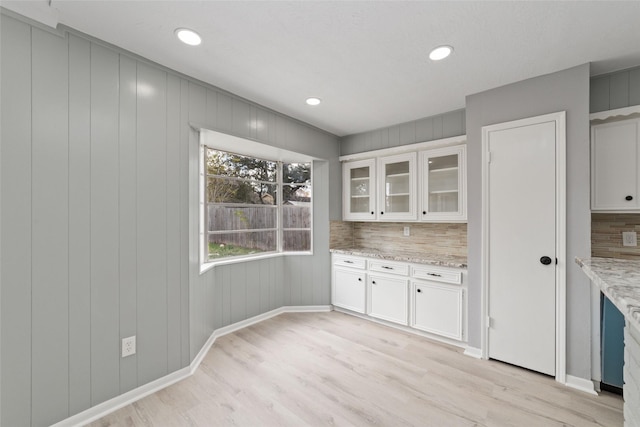 kitchen with light stone counters, decorative backsplash, and white cabinets