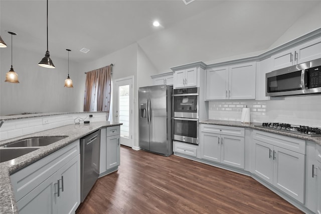 kitchen featuring sink, tasteful backsplash, decorative light fixtures, stainless steel appliances, and light stone countertops