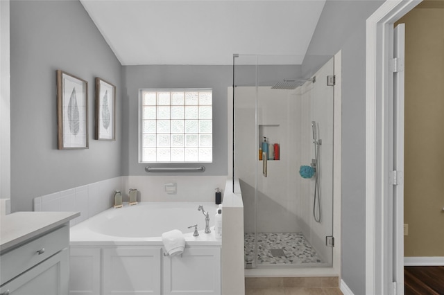 bathroom featuring vanity, lofted ceiling, and separate shower and tub