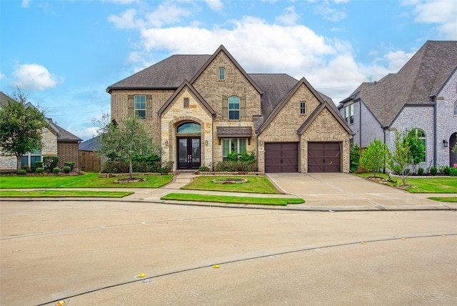 view of front of house with a garage, a front lawn, and french doors