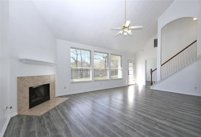 living room with a tile fireplace, high vaulted ceiling, ceiling fan, and dark hardwood / wood-style floors