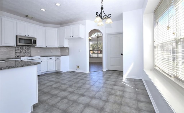 kitchen with white cabinets, decorative light fixtures, decorative backsplash, a chandelier, and white gas range oven