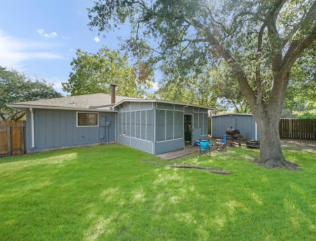 back of property with a sunroom and a lawn