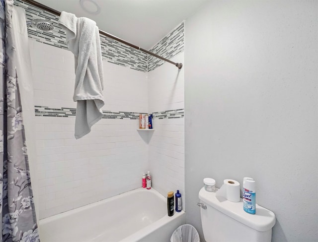 bathroom featuring shower / bathtub combination with curtain and toilet