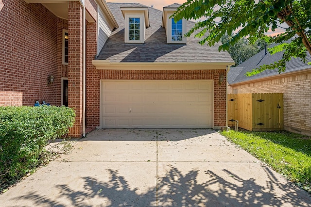 garage featuring concrete driveway and a gate