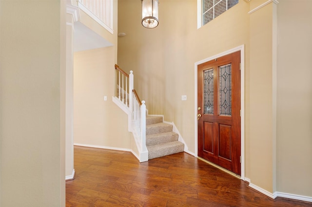 entryway with dark hardwood / wood-style flooring and a high ceiling