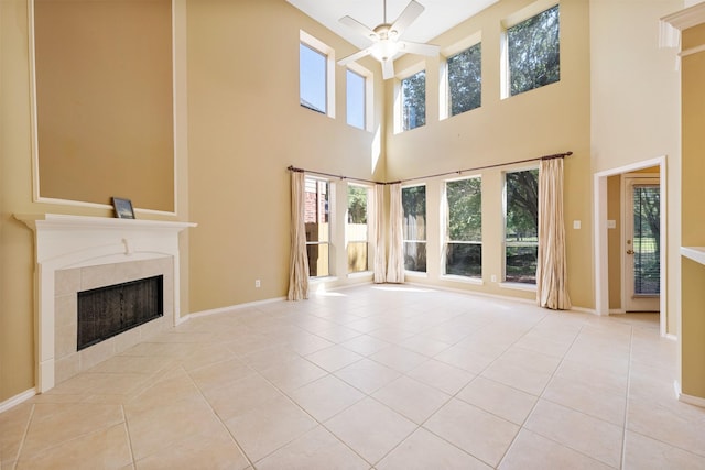 unfurnished living room featuring light tile patterned flooring, ceiling fan, and a tiled fireplace