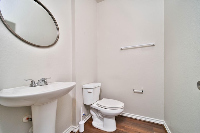 bathroom with sink, toilet, and hardwood / wood-style floors