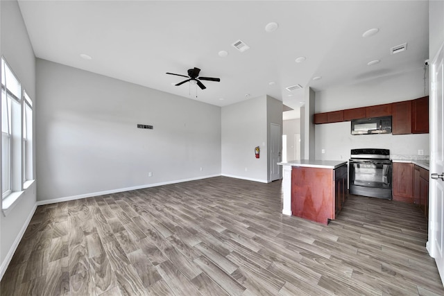 kitchen featuring light hardwood / wood-style flooring, black appliances, a center island, and ceiling fan