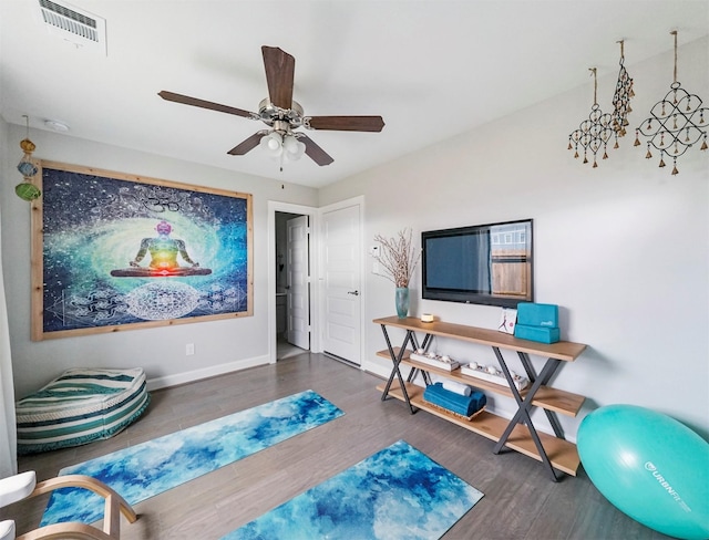 workout room featuring dark hardwood / wood-style floors and ceiling fan