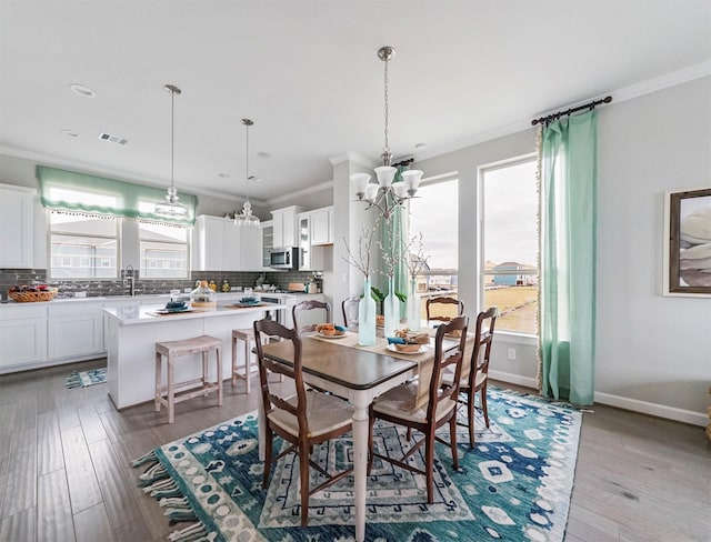 dining room featuring crown molding, plenty of natural light, and light hardwood / wood-style flooring