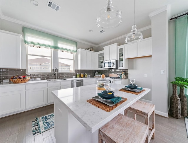 kitchen featuring white cabinetry, sink, a center island, and appliances with stainless steel finishes