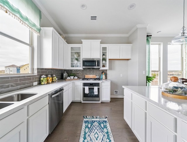 kitchen featuring stainless steel appliances, white cabinetry, tasteful backsplash, and decorative light fixtures