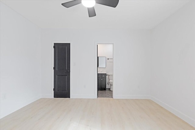 6609 Ave Q, Houston, TX 77011 - unfurnished bedroom featuring a ceiling fan, connected bathroom, baseboards, and wood finished floors