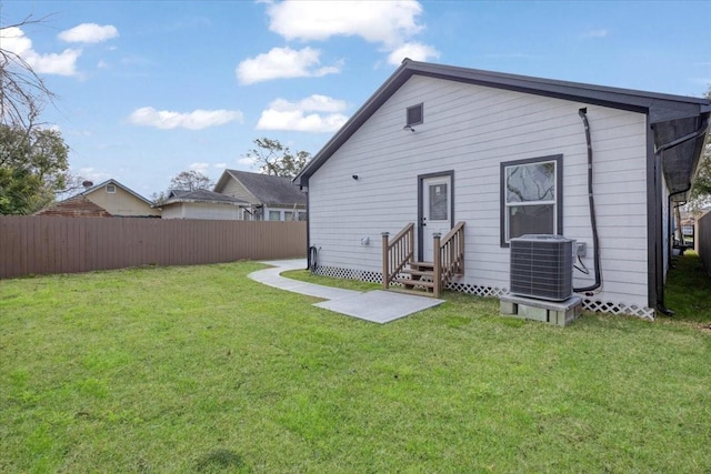 6609 Ave Q, Houston, TX 77011 - rear view of property with entry steps, a lawn, fence, and central AC