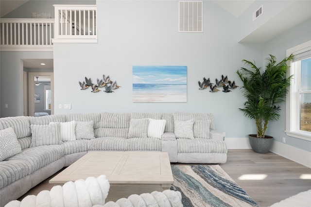 living room featuring hardwood / wood-style flooring and high vaulted ceiling