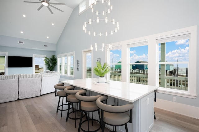 kitchen with white cabinetry, hanging light fixtures, and light hardwood / wood-style flooring