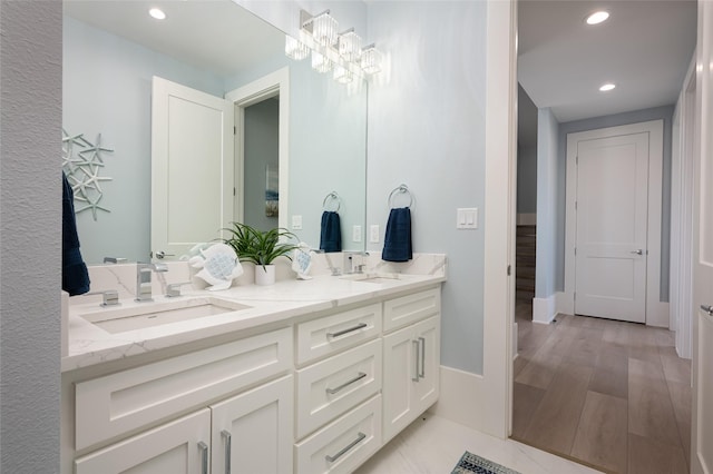 bathroom featuring vanity, hardwood / wood-style floors, and a notable chandelier