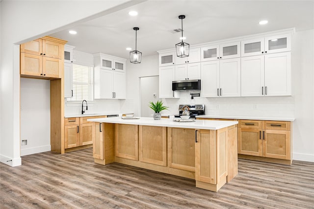 kitchen with sink, white cabinetry, wood-type flooring, a center island, and stainless steel appliances