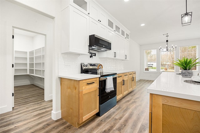 kitchen featuring wood-type flooring, hanging light fixtures, white cabinets, stainless steel electric stove, and backsplash