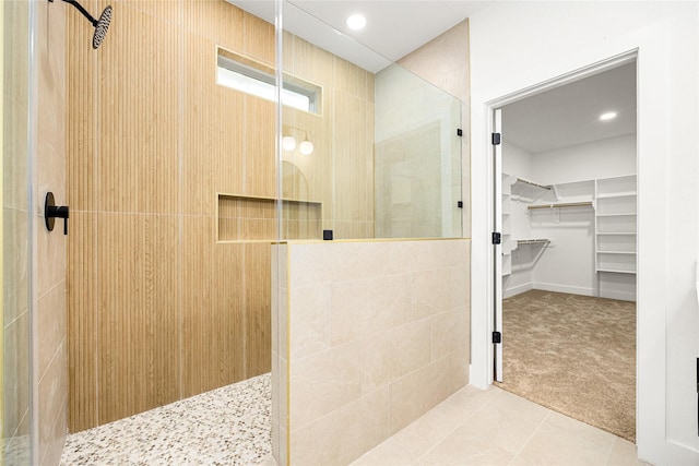 bathroom with tiled shower and tile patterned floors