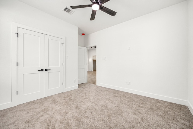 unfurnished bedroom with ceiling fan, a closet, and carpet