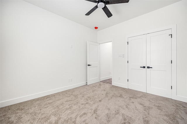 unfurnished bedroom with carpet floors, a closet, and ceiling fan