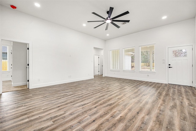 unfurnished living room with plenty of natural light, ceiling fan, and light hardwood / wood-style flooring