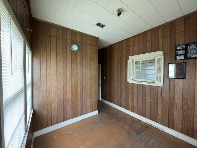 empty room featuring dark hardwood / wood-style floors and wood walls