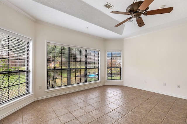 tiled empty room featuring ceiling fan, ornamental molding, and a textured ceiling