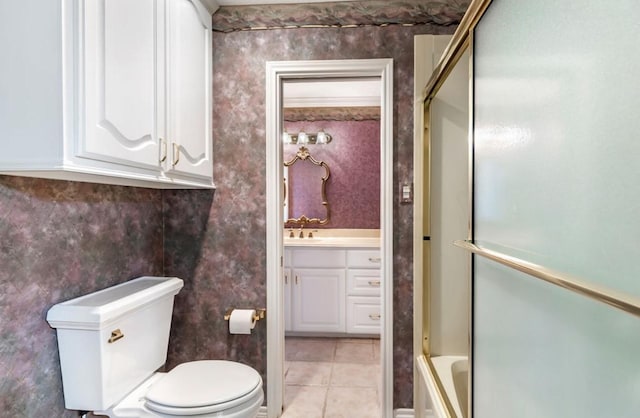 full bathroom featuring tile patterned flooring, vanity, enclosed tub / shower combo, and toilet