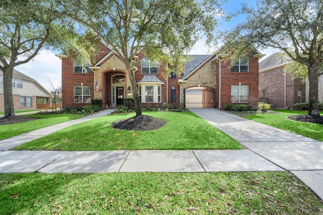 traditional-style home with brick siding, a garage, stone siding, driveway, and a front lawn