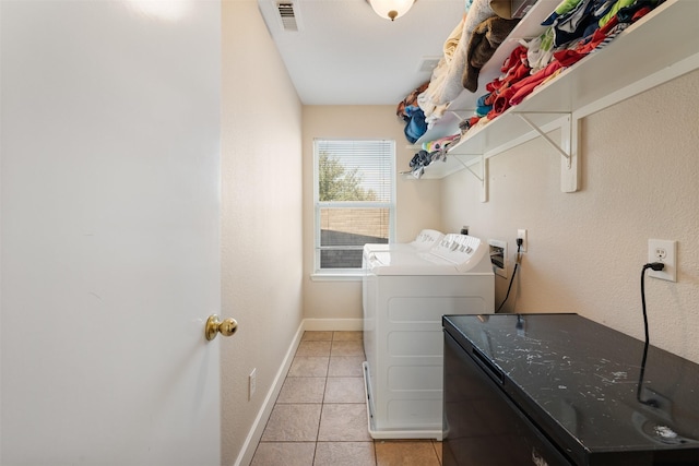 clothes washing area featuring washing machine and dryer and light tile patterned floors