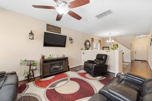 living room with hardwood / wood-style flooring and ceiling fan with notable chandelier