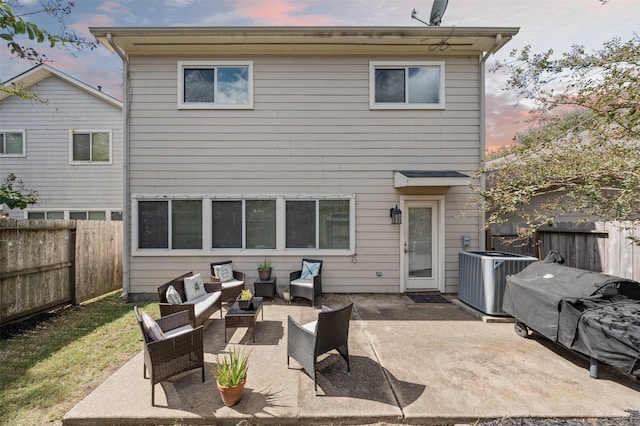 back house at dusk featuring an outdoor hangout area, a patio, and central air condition unit