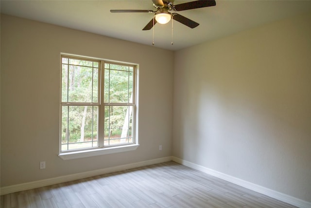 empty room featuring ceiling fan, baseboards, and wood finished floors