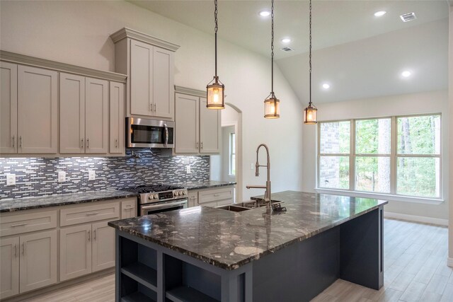 kitchen with tasteful backsplash, appliances with stainless steel finishes, vaulted ceiling, open shelves, and a sink
