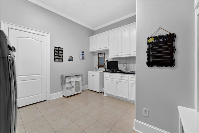 7611 Kings River Ln, Humble, TX 77346 - kitchen featuring ornamental molding, freestanding refrigerator, white cabinetry, light tile patterned floors, and baseboards