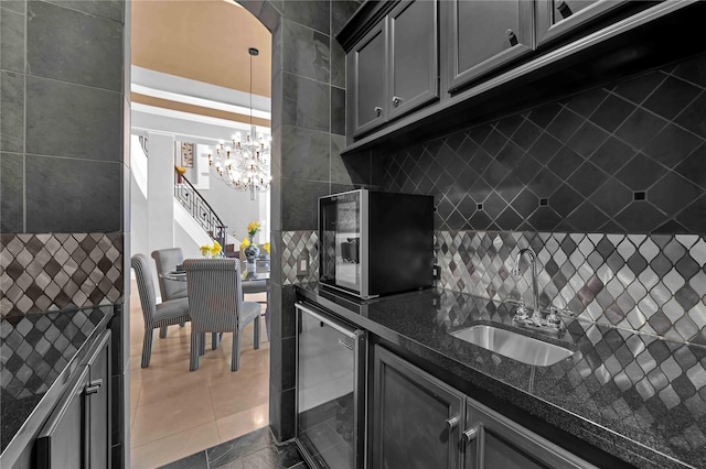 7611 Kings River Ln, Humble, TX 77346 - kitchen featuring beverage cooler, a sink, a chandelier, dark stone counters, and tasteful backsplash