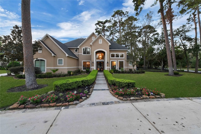 7611 Kings River Ln, Humble, TX 77346 - view of front of home with stucco siding, a front lawn, and french doors