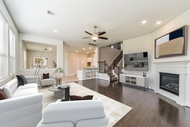 living room with dark hardwood / wood-style floors and ceiling fan