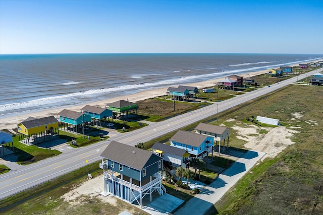 birds eye view of property with a water view and a beach view