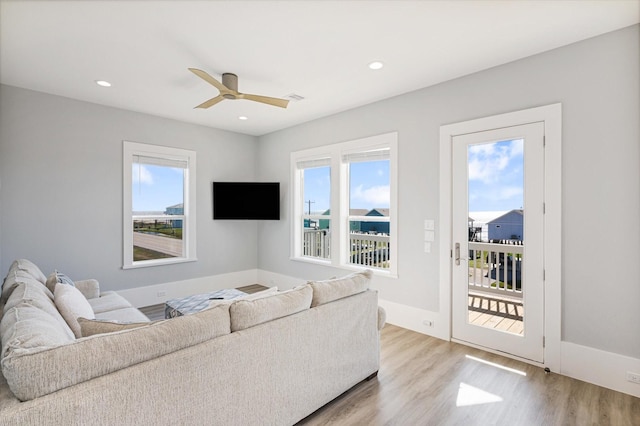 living room with light hardwood / wood-style floors and ceiling fan