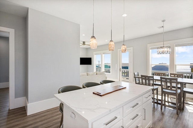 kitchen featuring pendant lighting, a wealth of natural light, white cabinets, and a kitchen island