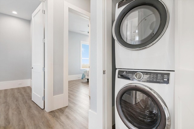 washroom featuring stacked washer / drying machine and light hardwood / wood-style floors