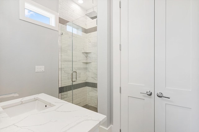 bathroom with vanity and a shower with shower door